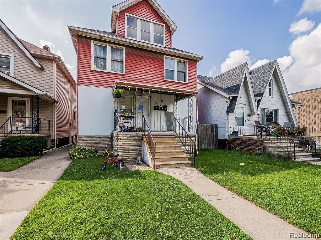 Two-story residence featuring red siding and a prominent front porch