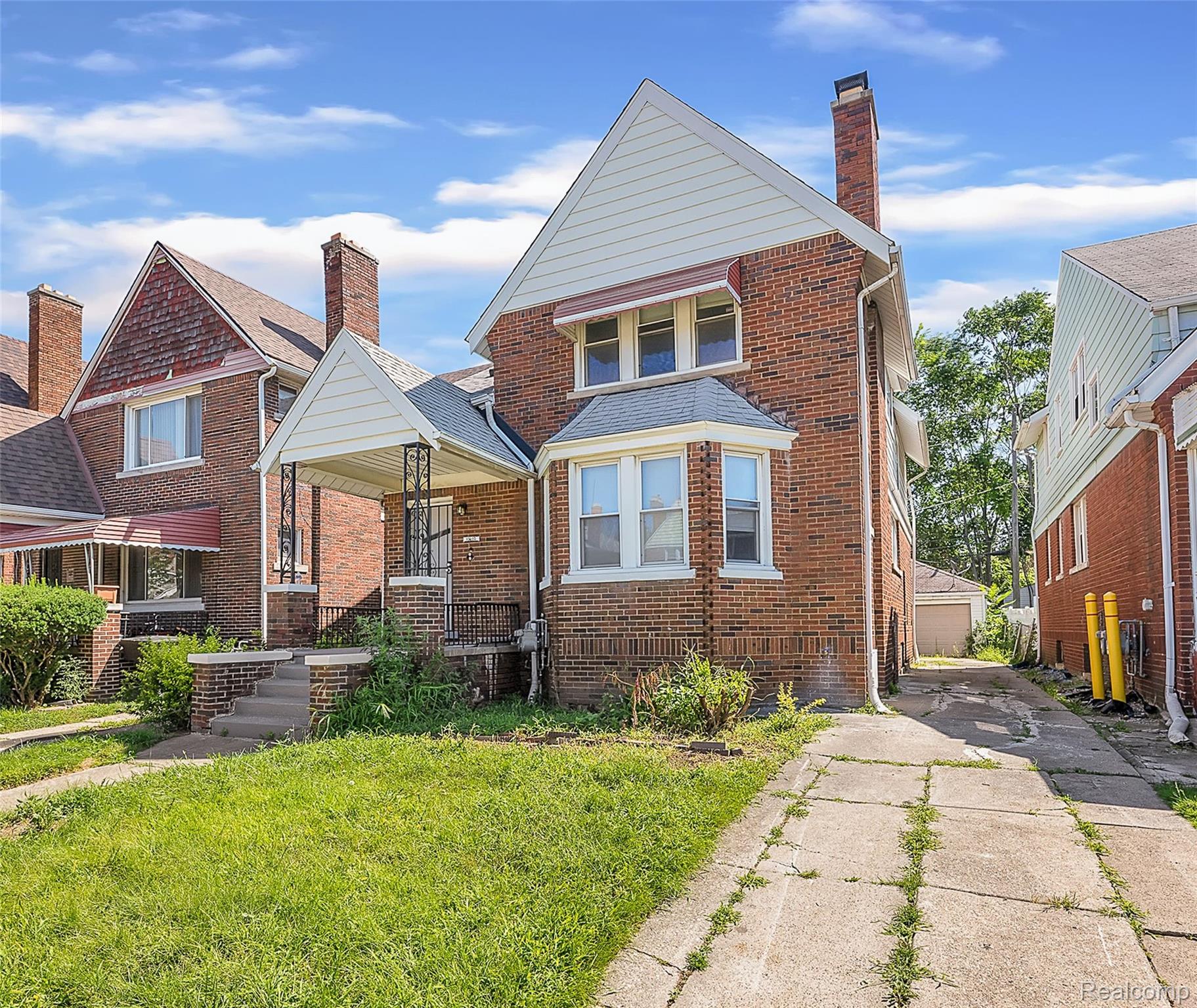 Brick exterior home featuring a bay window, covered front porch, and concrete driveway