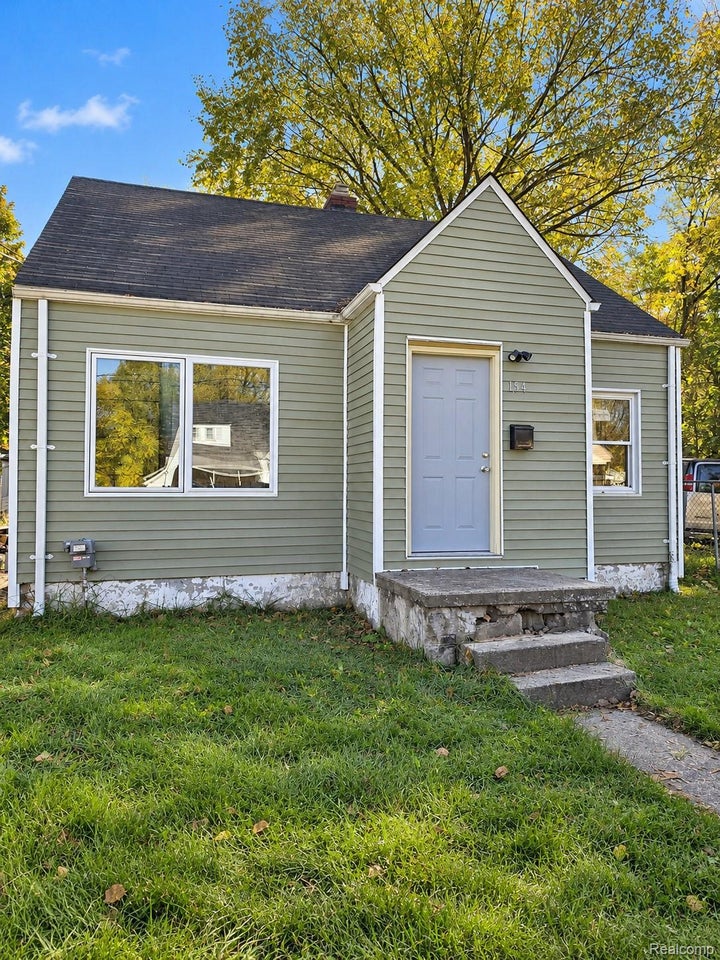 Exterior featuring horizontal siding, a gabled roofline, concrete entry steps, and a multi-pane fixed window
