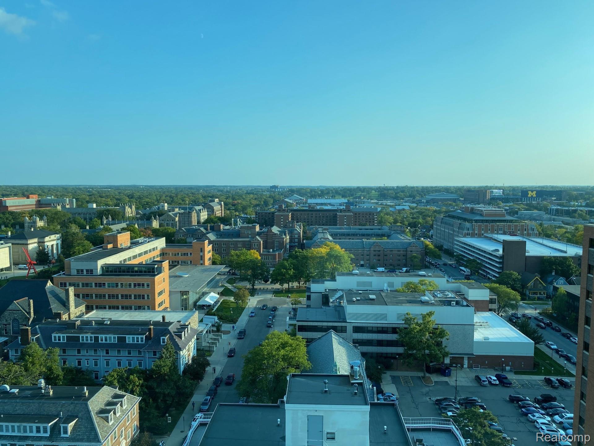 Expansive cityscape with a diverse architectural landscape, featuring various building styles and mature tree canopies