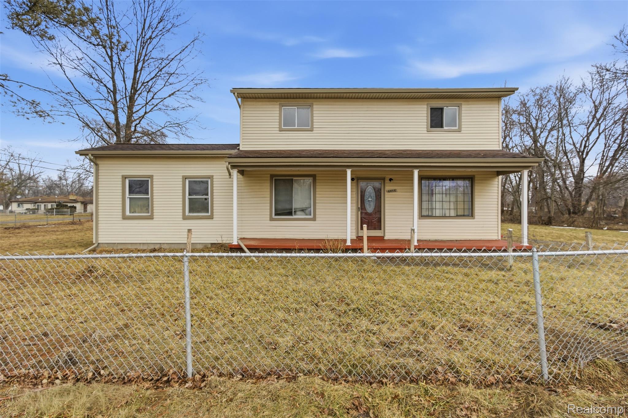 Traditional-style home with a porch and a fenced front yard