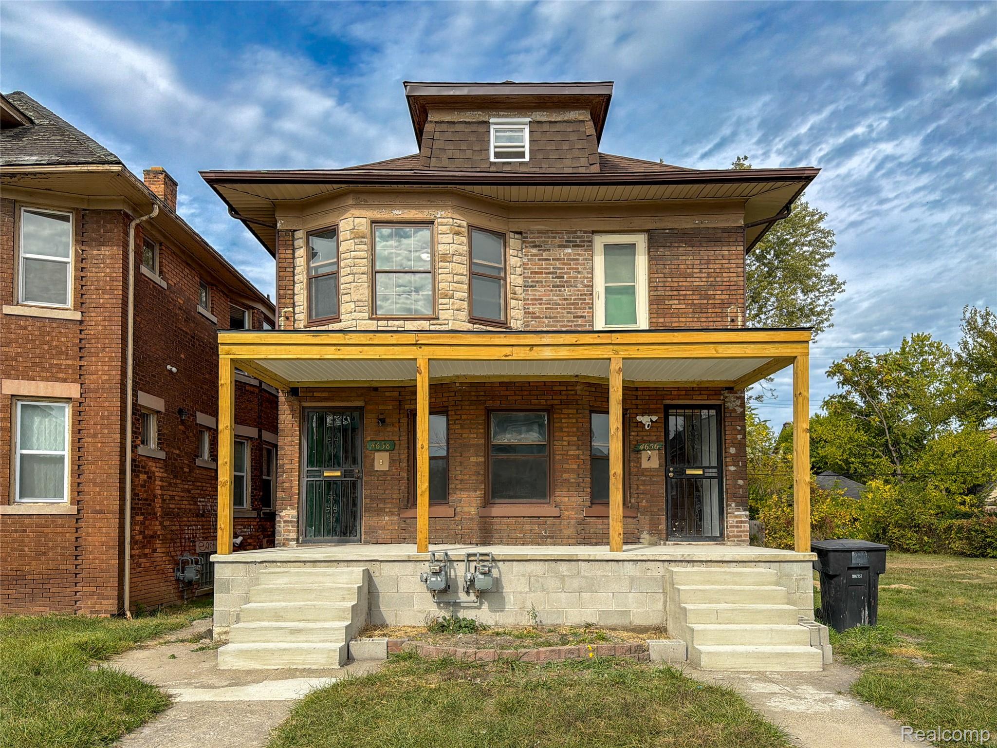 Traditional style home featuring brick siding and covered porch