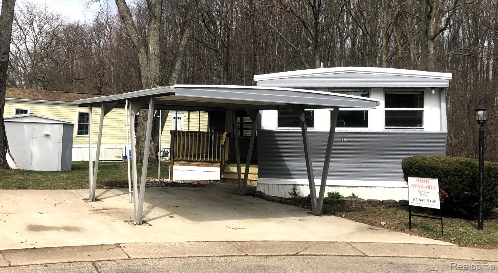 Manufactured / mobile home with a shed, a carport, and concrete driveway