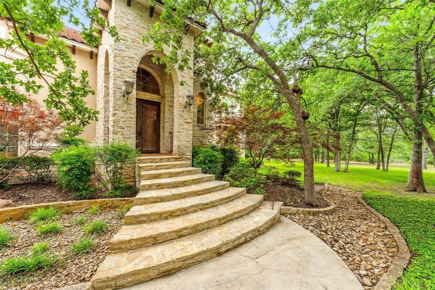 Step into unparalleled luxury with this Mediterranean-style masterpiece nestled on six manicured acres in the heart of Stephenville. Designed for those with discerning taste, this custom-built estate blends timeless architecture with world-class finishes and resort-style amenities. From the moment you enter, imported Costa Rican teak floors and hand-selected Mexican columns make a bold statement of elegance. Soaring 22.5-foot cathedral ceilings in the grand living room are crowned with Juliet balconies, creating a breathtaking backdrop for unforgettable entertaining. The chef’s kitchen is a culinary dream, featuring a generous island bar, built-in appliances, and seamless flow into the living and dining areas. A private first-floor guest suite offers luxury and comfort, while an executive office and tornado-safe room provide functionality and peace of mind. Upstairs, a media and game room with a built-in wet bar invites you to unwind in style. But the crown jewel is the resort-caliber backyard: a freeform pool with a cascading waterfall and hidden grotto, heated spa, expansive patios with a full outdoor kitchen, firepit, and multiple balconies—all framed by mature trees and tiered, lush landscaping. Whether you're hosting lavish soirées or enjoying serene sunsets, this estate delivers the lifestyle you’ve dreamed of—elegant, private, and absolutely unforgettable.