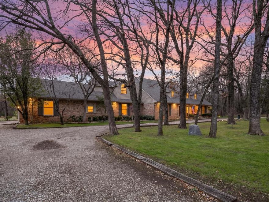 This rustic contemporary lodge estate blends timeless architectural character with refined craftsmanship and is privately situated on nearly four acres beneath a canopy of mature oak trees in the heart of Copper Canyon. A circular drive and expansive covered front porch create a memorable sense of arrival and reflect the home’s impressive estate-scale presence.

Inside, the home is thoughtfully designed around multiple gathering spaces ideal for both entertaining and everyday living. A dramatic library serves as a signature architectural centerpiece, featuring a spiral oak staircase, cherry wood cabinetry and shelving, coffered ceiling, custom illuminated built-ins, and a striking verde granite fireplace. A custom interior kitchen with cherry wood cabinetry, premium appliances, and wine refrigeration anchors the home as a natural gathering space. TWO primary suites offer exceptional flexibility for guests, extended family, or multi-generational living.

Two expansive great rooms, each with its own fireplace & French doors, open seamlessly to the outdoor living areas, while a wall of windows frames scenic views of the landscaped grounds and fills the home with natural light. The outdoor environment functions as a private retreat, highlighted by a PebbleTec saltwater pool and spa, cascading water features, fire bowls, landscape lighting, hand-laid brick patios, and a covered outdoor kitchen and pavilion. Designed for year-round enjoyment, enjoy the media center, premium outdoor stereo speakers, a 3CM granite counter, a translucent, under-lit Onyx bar countertop, plus a propane grill & fireplace. 

This distinctive estate combines privacy, craftsmanship, and a lifestyle centered on entertaining and connection to nature. Ideally located with convenient access to FM 407, I-35W, and I-35E, and just minutes from Lewisville Lake, as well as shopping, dining, and entertainment in Highland Village, Flower Mound, and Denton.  The home is also ~17 miles from DFW Airport.