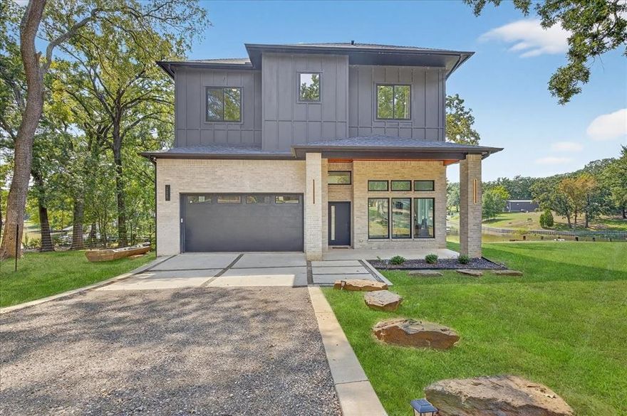 Very Motivated Seller! This stunning modern custom built lakefront home offers 4 bedrooms, 3 baths, and an open floor plan designed for both luxury and comfort. Soaring 13 foot vaulted ceilings on both levels and dramatic 30 foot ceilings in the living room frame floor to ceiling windows with breathtaking lake views. The gourmet kitchen features oak cabinets with gold hardware, stainless steel appliances, a gas range, and seamless porcelain counters in kitchen and quartz countertops are three inch thick.  Oversized bedrooms boast walk in closets with custom systems, while the downstairs office can easily convert into a 4th bedroom, builder is happy to install the door after closing if desired. Built with quality, this home comes with a 10 year foundation warranty. Perfect for full time living or investment, STR or Airbnb is allowed. Situated on nearly half an acre with two private boat slips, accordion doors open to an oversized patio ideal for entertaining. The 13 foot ceiling garage accommodates large vehicles or extra storage. Vacant lot is available for purchase also. Too many features to list. Come see for yourself. Life is short… buy the lake house!