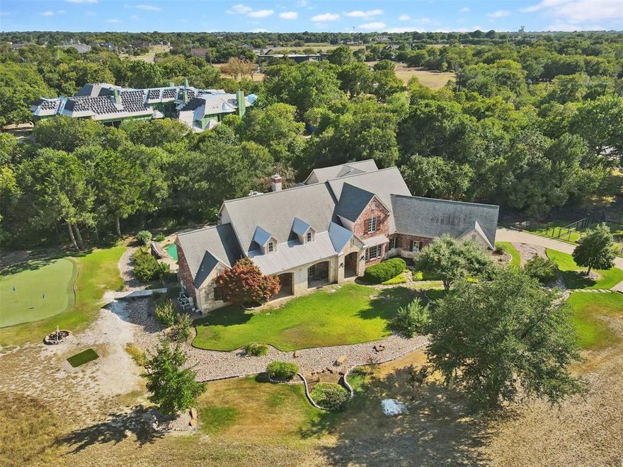 Extraordinary estate on 3.9 acres of peaceful land within the sought-after Lovejoy ISD. This property is a true rarity. Native trees, a field of bluebonnets, and unrivaled views of White Rock Creek that set it apart from any other. Inside, the home is a masterpiece of design, featuring soaring ceilings, intricate millwork, and floor-to-ceiling windows that frame stunning views in every room. LR overlooks a dramatic stone fireplace and expansive windows that flood the space with natural light. Master sanctuary, complete with access to a screened porch, a spa-inspired bath, and a double-sided fireplace that also warms the adjoining executive office. The chef’s kitchen and butler’s pantry flow seamlessly into the formal dining and family rooms, which includes a wine cellar, making this estate ideal for grand-scale entertaining. Outside, find a lagoon-style pool, spa, firepit, putting green, and an outdoor dining area perfect for gathering.