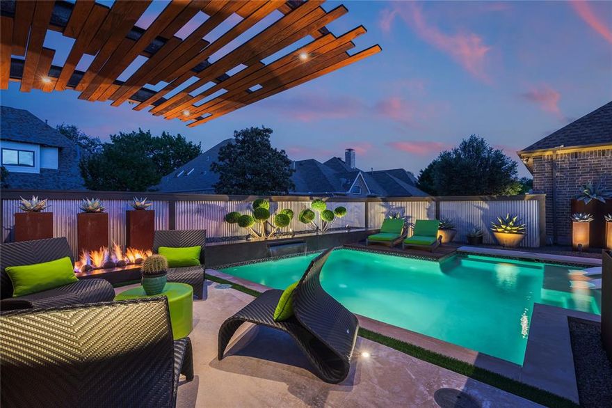 A truly one-of-one showpiece, this exceptional residence is positioned in the highly sought-after Ballantrae enclave of Stonebridge in McKinney. From the moment you arrive, the home’s striking curb appeal sets the tone—lush landscaping is enhanced by a professionally designed outdoor lighting system by Signature Illuminations Designs, creating a memorable presence day and night. The resort-caliber backyard, designed by Aquaterra Outdoors and showcased as “Shadywood,” is extraordinary. Anchored by a stunning resort-style pool, the space is built for relaxation and elevated entertaining. A 10-foot fire pit with an 8-foot burner serves as a dramatic focal point, while a custom steel-framed IPE wood pergola provides a refined lounge setting. The fully equipped concrete outdoor kitchen—featuring a large Green Egg, stainless steel drawers, and custom cabinetry—is complemented by a striking steel-framed IPE wood backdrop. Inside, an open, light-filled layout pairs with modern finishes that exude warmth and sophistication. The grand entry showcases custom Alder detailing, while a floating wood and steel staircase creates a bold architectural statement. A private office overlooking the backyard offers a serene workspace. The chef-inspired kitchen, renovated in 2024, features a beamed ceiling, upgraded lighting, designer tilework, new countertops, soft-close cabinetry, and premium appliances—ideal for everyday living and entertaining. The 1st floor primary suite is a true retreat, complete with a spa-like bath featuring a double concrete sink atop a custom Tiger wood vanity, Italian porcelain tile, an oversized shower with built-in seating, and a bubble massage air bath. Upstairs, two additional bedrooms and a spacious game room provide flexibility. An oversized 2 car garage with epoxy flooring, a Container Store storage system, and a workbench adds prime functionality. Thoughtfully curated, this home presents a rare opportunity to own a distinctive McKinney property.