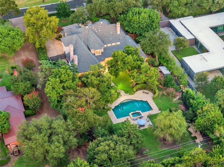 Nestled in one of Dallas’ coveted hidden enclaves of Preston Hollow, this timeless French Transitional estate is where elegance meets serenity on a nearly full acre of exquisitely landscaped grounds. Tucked behind mature trees and set amid lush lawns, a sparkling pool and expansive green space are perfect for play, pets, your dream cabana, or guest house. Built and cherished by a single family since 1999, this 4-bedroom sanctuary is more than a home and waiting for someone to make it their own. A grand entry sets the tone, flanked by formal spaces and flowing seamlessly into a gourmet kitchen made for celebration. Step outside and let the home extend its arms—retractable screens open to an outdoor living area that lives like a second great room, perfect for quiet mornings or evening entertaining. Both a formal library and a second office or nursery grace the expansive first level. Multiple staircases rise to spacious secondary suites and gameroom, while the downstairs primary suite is a haven all its own—featuring a spa-like bath, tranquil views, and a hidden safe room for peace of mind. From the stately circular drive to the three-car garage with extra storage, every inch of this home whispers refinement and quiet luxury. Your Preston Hollow retreat awaits.