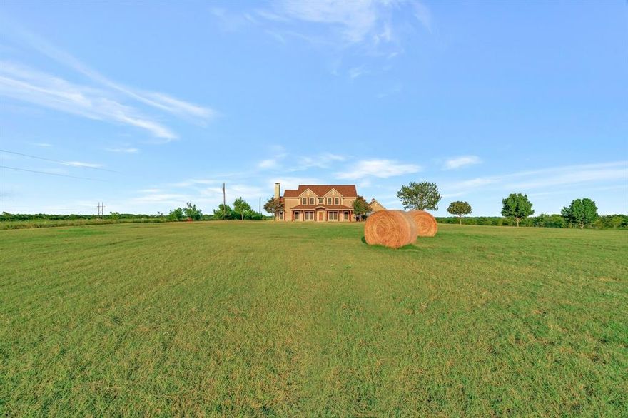 Rare Opportunity to own land on historic site of Superconducting Supercollider! This gated, 12.51 acre, prairie-style ranchette boasts 10 acres of Coastal bermuda w 14x60 shop & 3522 sq ft custom home on 2.5 acre homestead. Enjoy watching private planes take off & land at Midway Regional Airport or drink in the magnificent sunsets & brilliant starry sky on the extended front porch. Springtime surprises with a blanket of bluebonnets & Indian paintbrush. Rustic, cedar pillars & solid Knotty Alder door invite you inside. Stained, glass-paneled, French doors lead to the handsome office with access to the primary suite. Expansive two-story living area w vaulted ceiling & Austin stone gas-log fireplace-an entertainers' delight! Wood flooring in living, dining and entry. Commercial kitchen impresses with Imperial stainless steel, gas, 6-burner stove, 24x24 griddle & 2-36 in. full-sheet ovens and custom, commercial vent-a-hood. Custom solid wood cabinets, & commercial frig, too. Massive commissary or craft room off kitchen. Snuggle up to the flicker of the 2nd stone fireplace in the primary suite. Ensuite bath has been recently renovated w freestanding soaking tub w waterfall faucet, solid wood vanities w Carrara marble countertops, ceramic, apron sink & walk-in shower. Utility boasts extensive upper & lower cabinets, sink, bonus counter prep space, & ice machine! Built-in ironing board & electric or gas dryer hook up, too!
Three generous secondary bdrms enjoy attached bath & ceiling fans. Substantial flex room includes built-in desk, fan, and cabinets.
1460 sq ft insulated shop w steel frame construction & 12 in. slab, 2 entry-bay doors w add'l interior bay door to create 20 ft section. Full electrical, overhead lighting. Stubbed for water in the 20 ft section. 2 hose reels. Compressor mounted on slab behind building. Four-rail pipe fence, swing gate entry & remotes. Perimeter fencing is barbed wire. 40-yr, inpact resistant fiberglass reinforced comp shingles.