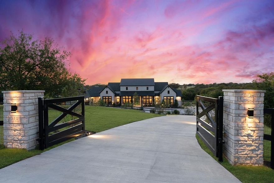 This stunning luxury farmhouse nestled on 4.8 picturesque acres offers almost 6500 square feet in a 1 story open layout that balances elegance with comfort. Every element of this 4 bedroom home is thoughtfully designed with a fully upgraded gen suite. The gated entrance leads you to the front circle drive and welcoming front porch. The interior details of designer lighting, wood beams, vaulted ceilings, and expansive windows encompass the open concept home. The luxurious kitchen offers professional grade appliances, detailed custom cabinetry, and an expansive island as a centerpiece completed by a beautiful farmhouse sink and pendant lighting.  The primary suite secluded at the rear of the home is thoughtfully designed with a luxurious bath and custom closets. The secondary bedrooms are oversized with ensuite bathrooms and walk in closets.  Bedroom 4 is a full 630 sq ft gen-suite serving as a second primary suite with full size kitchen, single car garage access, and a TV sitting area. The game and media room is completed with wet bar and surround sound.  The laundry room connects to the primary closet and offers ample cabinets and counters, a sink, and space for full size refrigerator. The executive study allows for a great work from home space.  Closets and storage rooms are found through out with a family sized safe room.  The main garage is both wide and deep with 8 foot tall doors for parking oversized vehicles.  Do not miss the electric lift and stairs leading to the fully decked storage space above the garage. The covered outdoor living space with fireplace, built in grill and beverage fridge and motorized screens will not disappoint capturing the best view of Texas sunsets.  Head to the rear of the property to find mature trees and serene creek and a perfect pasture for horses or other livestock.  The property has a low tax rate of 1.67. A country retreat away from the city offering peace, tranquility, and a deep connection to nature. Enjoy easy access to 75.