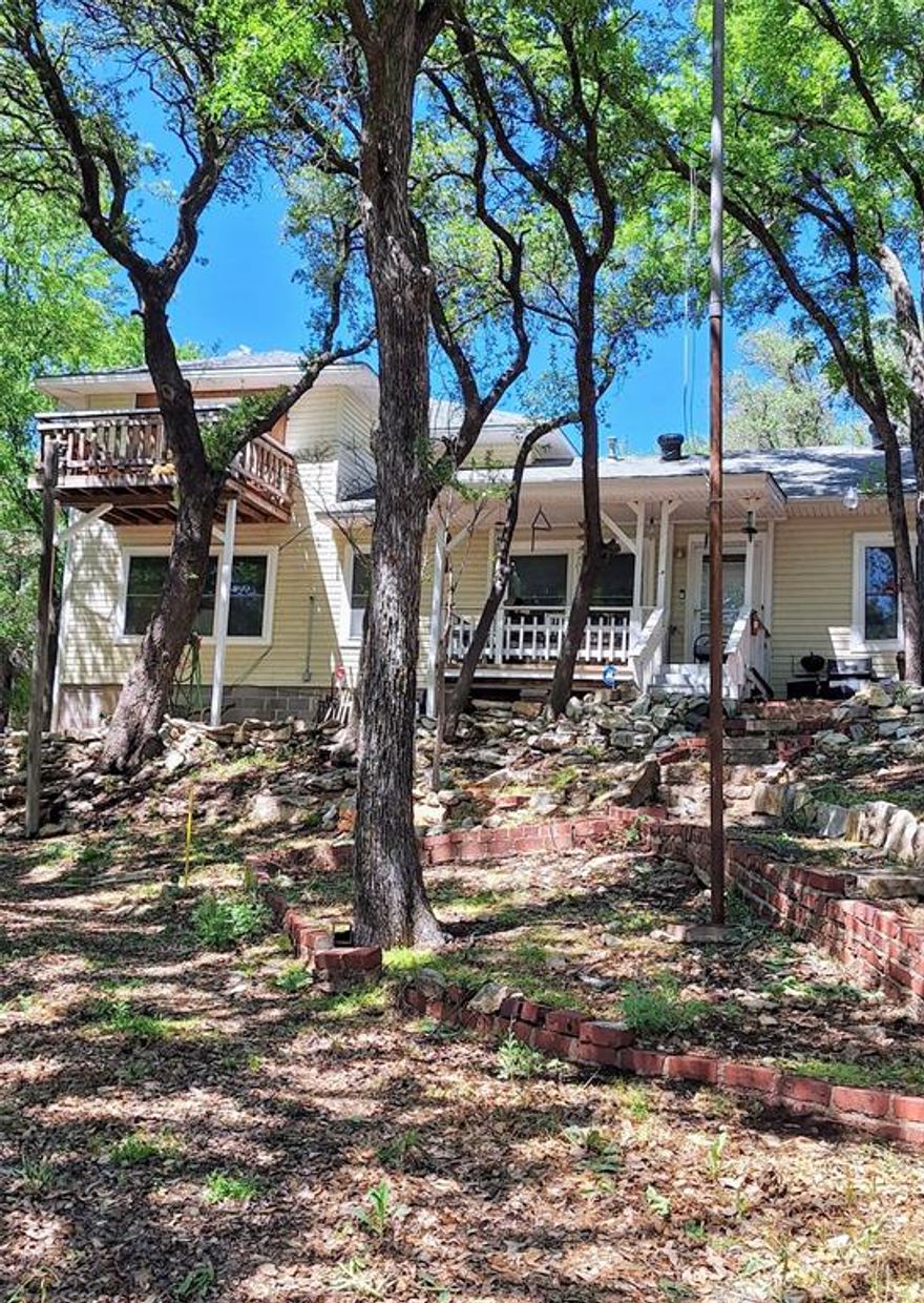 Very nice, 1.5 story lake front home with such exterior features as multiple seating areas, a double carport, a large, detached garage with 3 roll up doors and a smaller storage shed, 3 covered entrances and second story deck off an upper bedroom. Waterfront area includes a covered boat dock, with several rod holders, and a concrete retaining wall. Utilities for the house are served by an aerobic septic system, a liquid propane tank and an HVAC unit. The interior contains 3 to 4 bedrooms, 3 full bathrooms, a kitchen and dining area and living area, which could also serve as a formal dining area. Closets are in abundance, with several walk-ins throughout both floors. Carpeted stairs lead to a second-floor landing with two of the bedrooms and one bathroom along the hall, as well as a lockable closet across the landing. There are two additional bedrooms and bathrooms downstairs, with the ensuite off the large bedroom containing two vanity areas, a jetted tub and a separate toilet and shower area. This property has many unique features that make it ideal for your vacation home or your permanent home to find relaxation.