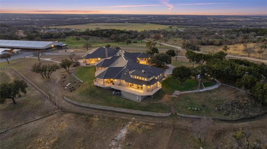 Perched atop one of the highest vantage points in Parker County, this extraordinary gated estate captures breathtaking panoramic views and offers a rare blend of luxury living and world-class equestrian amenities. Designed for both grand-scale entertaining and refined ranch living, the impressive 10,438 sq ft custom residence showcases thoughtful architecture, expansive living spaces, and exceptional craftsmanship throughout. Large windows frame the sweeping countryside while generous gathering spaces provide the perfect setting for hosting family, friends, or large events. 

The chef’s kitchen is built for both beauty and function, featuring high-end appliances, abundant workspace, and a fully equipped secondary butler’s kitchen that makes entertaining effortless on any scale. 

Equestrian facilities rival those found at elite training operations. A covered arena allows for year-round riding and training, while the meticulously designed 19-stall show barn reflects unparalleled attention to detail and quality construction. Multiple spacious turnouts provide excellent horse management and flexibility, while ample implement parking and equipment storage support the functionality of a premier working ranch.

From the private gated entrance to the commanding hilltop setting, every element of this property has been carefully curated to deliver an exceptional lifestyle for the discerning buyer. This is a rare opportunity to own a premier Parker County estate where luxury living, breathtaking views, and first-class equestrian facilities come together in one remarkable property.