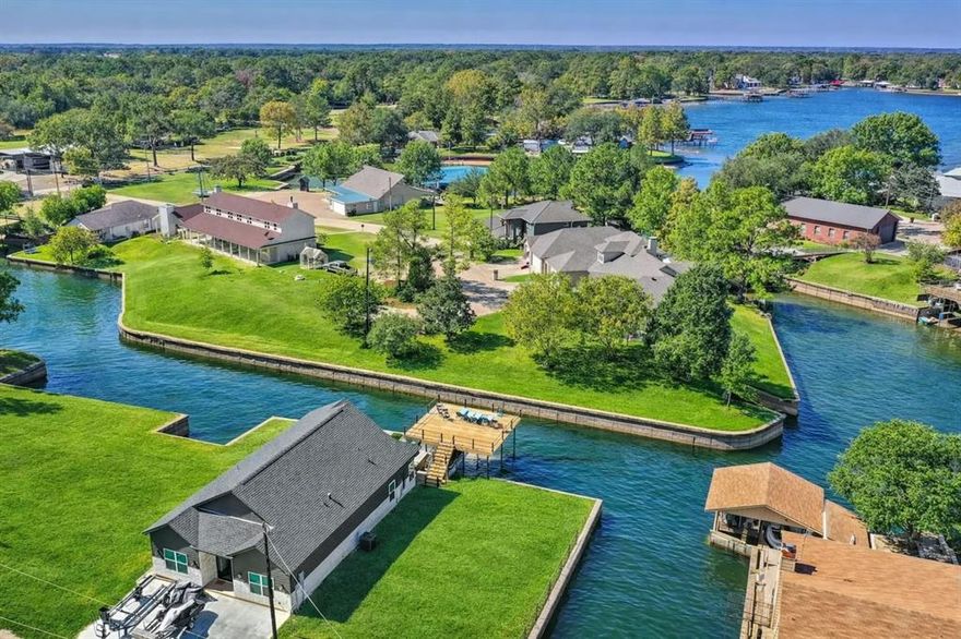 Hilltop Escape is a luxury waterfront retreat in the sought-after Treasure Isle community on the clear southern end of Cedar Creek Lake, known for excellent fishing and exceptional water quality. This recently built modern farmhouse features upscale finishes, soaring vaulted beam ceilings, abundant natural light, and a split-bedroom floor plan designed for privacy and comfort. The waterside primary suite includes a spa-inspired bath with a soaking tub, separate shower, dual vanities, and a spacious walk-in closet, while the chef’s kitchen showcases quartz countertops, premium appliances, and an oversized island ideal for entertaining. Outdoor living includes peaceful cove views from the covered patio and an expansive party deck above the private boathouse. Located in a site-built-only community with four-vehicle parking, the home sits approximately 80 minutes from Far North Dallas, making it an ideal lock-and-leave weekend retreat. With a strong short-term rental history on Airbnb and VRBO, and furnishings, boats, and recreational equipment available for purchase, Hilltop Escape is a turnkey lakefront opportunity.