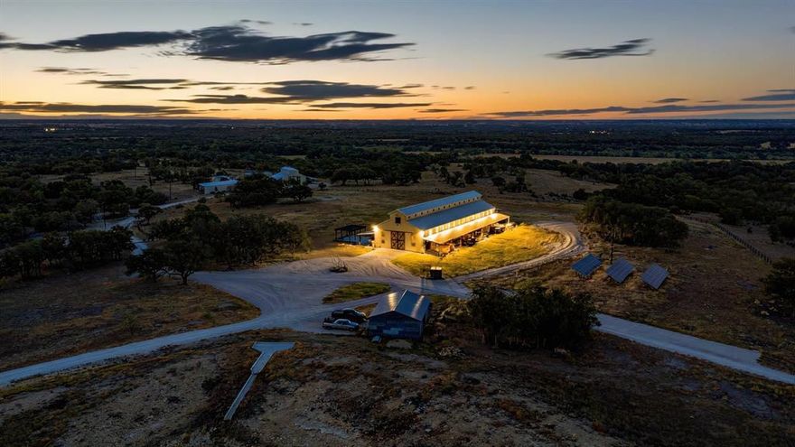 This 55± acre estate blends luxury, comfort, and flexibility with over 3,500 ft of paved frontage. The 10,000± SF barndominium lodge features a spacious open living area, chef’s kitchen with Wolf appliances, and a dramatic 2,500 SF great room with full bar, soaring ceilings, glass walls, and retractable sides for panoramic views. Three master ensuites plus a second-floor retreat with kitchen, baths, and office provide ample accommodations. Outdoor living shines with 8,200 SF of porches, pergola patio, fireplace, and indoor,outdoor bars. Four solar-powered guest cabins and solar backup for the lodge add sustainable peace of mind. The land is fully fenced with two ponds, ideal for recreation or livestock. Just outside Gatesville, convenient to Waco, Temple, and Austin. Perfect as a forever home, retreat, venue, wellness retreat or corporate getaway, with 159± additional acres and Leon River frontage available.