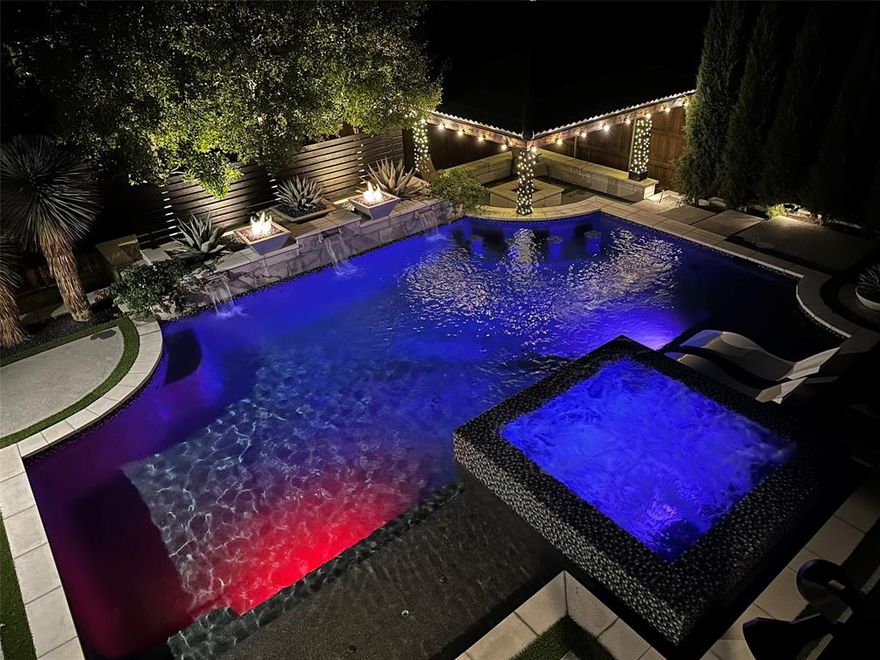 Discover perfection in this contemporary gem meticulously preserved for an exceptional living experience. An entertainer's paradise, the outdoor haven mirrors a lavish 5-star resort with a lush turfed yard, inviting heated pool, expansive hot tub, swim-up bar, and captivating fire pit embraced by azure blue fire pots and a poolside pavilion. The gourmet kitchen shines with a Bertazzoni 6 Burner range and dbl.oven, Fischer & Paykel dual SS refrigerators, freezers, dual dishwashers with 2 drawers ea., and striking Calcutta quartz countertops with a coordinated backsplash. The 1st fl.Primary ste. offers breathtaking pool views with enchanting cascading fountains. Spa-like bathroom with Garden tub, dual showers,2 WIC. Dynamic game room with Brunswick pool tbl., and a state-of-the-art media room, your home becomes your oasis. Every detail has been meticulously curated, from the impact-resistant roof to heightened security and elegant art lighting.  Exceptional living awaits! Brava Roof