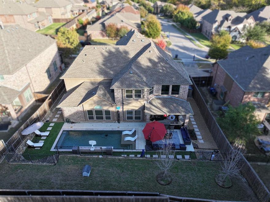This beautifully maintained North McKinney home offers a great balance of space, comfort, and thoughtful upgrades throughout. With over 4,300 square feet, 5 bedrooms, and 4.5 baths, there’s plenty of room to spread out while still feeling connected. As you walk in, you’re greeted by a bright, open living area with soaring ceilings and large windows that bring in tons of natural light. The living room flows easily into the kitchen, which is well-equipped with granite countertops, stainless steel appliances, newly replaced dishwasher and gas cooktop, and plenty of cabinet space, ideal for both everyday living and entertaining. The layout is especially functional, with a private guest suite downstairs that works well for visitors or multigenerational living, plus a dedicated office for working from home. The primary suite is also on the first floor and offers a comfortable retreat with a spacious bathroom, dual vanities, soaking tub, and separate shower. Upstairs, you’ll find 3 additional bedrooms along with a large game room and a media room that’s ready for movie nights, complete with tiered seating, projector-ready mounts, wired high end surround sound, and a wet bar setup. Step outside to your own private backyard paradise. Designed for year-round enjoyment, the outdoor space features a sparkling pool with a waterfall display, with pet-friendly installed AstroTurf, outdoor kitchen, firepit lounge area, mounted TV, and even an outdoor shower. The terraced and elevated yard provides extra privacy as well as serving as additional space for pets or as a blank canvas for recreational ideas such as a small pickleball court, making this backyard both functional and resort-like. Additional highlights include a 3-car garage, EV charging capability, and smart home features such as motorized blinds. Situated in the highly sought-after McKinney ISD and nestled within a desirable neighborhood, this home offers the perfect blend of upscale living and everyday practicality.