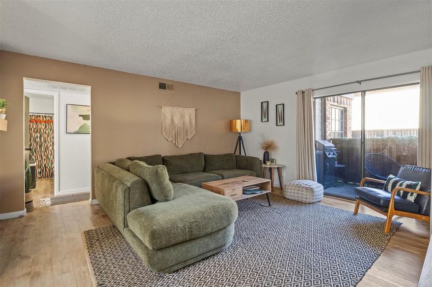 Nestled in a gated community and backing to a lush green space, this super cute first-floor, end-unit condo offers 2 bedrooms and 2 baths with an open, light-filled layout. The living area features a built-in wet bar, electric fireplace, and sliding glass doors that open to a private, fenced patio.
The kitchen is equipped with granite countertops, stainless steel appliances, a built-in pantry, and overlooks both living and dining spaces - perfect for entertaining. Wood-look flooring flows throughout the main living spaces, with plush carpeting in both bedrooms. The spacious primary bedroom includes TWO walk-in closets, while a dedicated laundry room provides ample additional storage space. Unit also comes with 2 assigned parking spaces (one covered) located directly out front.
The affordable HOA dues cover sewer, trash, water, and offer access to a community pool, clubhouse, and tennis courts. Ideally located just off the Dallas North Tollway and close to shopping, dining, and entertainment, this inviting condo truly has it all!