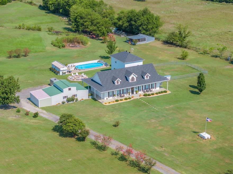 Magazine worthy east TX country estate on 15 acres. A gated drive and sprawling green pastures surround this newly remodeled and updated 3480-sq-ft home just outside the city limits. Wrapped in a classic full-length front and back porch and finished with fresh exterior paint, the home combines timeless style with all the modern updates for a stunning retreat. Inside the main home is an open living, dining and kitchen, 3 bedrooms and 2 full baths, a separate primary suite with ensuite bath, each of the 2 guest rooms are private, one has a built in Murphy bed.  Also, a large laundry room with plenty of storage space. From the recently added mud room, step into the attached 1200 sq-ft separate living quarters ideal for guests or multi-generational living, to 3 bedrooms, 1 bath, a game room, media room, and laundry room. The outdoor living here is at its best! From the sparkling pool with deck and cabana to the massive fire pit designed for unforgettable nights under the TEXAS stars, a private fishing pond, and manicured grounds are great for entertaining.  A 24x48 workshop with 3 bay doors also houses a finished private office, and additional storage, while a fenced dog area, chicken house and full perimeter fencing (already in agriculture for hay lower taxes) complete the picture. If you are searching for the charm and freedom of country living this rare east Tx find, checks every box! Wills Point ISD! MLS# 21064894 is a 5 acre parcel available.