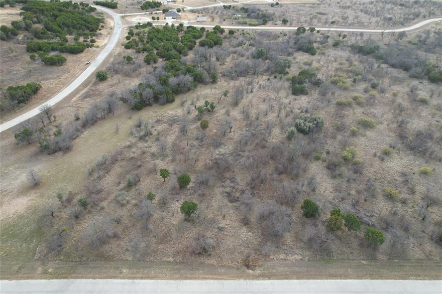 Four acre lot with a wet weather creek passing through a part of it. With proper building and placement a lake view could be possible. The Hills is a very social and rapidly developing community with access to Possum Kingdom Lake. Lot ownership includes the use of all the neighborhood amenities, including; boat storage area, community dock, boat ramp, lakefront area with fisihing and lakeside cabin, covered patio with grills, restrooms, clubhouse with pool and fitness center, fishing pond, walking trail, and twenty miles of private roadway behind the gates. The Hills is a gated community, please let the isting agent know your plans to visit so the gate may be opened for you on arrival.