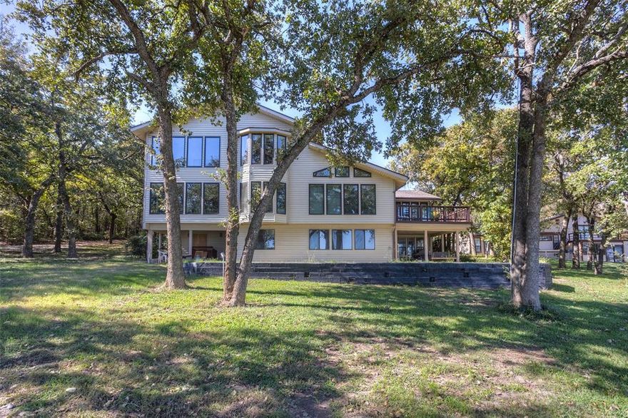 GORGEOUS LAKE FRONT ESTATE on pristine northwest side of Eagle Mountain Lake with beautiful trees and heart-stopping lake vistas; large home with beautiful, huge windows (Anderson) overlooking the lake; lake view from deck off kitchen and great room; enclosed sunrooms off primary and secondary bedrooms overlook lake; perfect home for entertaining large groups, with multiple living rooms and bedrooms; separate apartment on lower level with kitchenette, living room, bedroom, and lake front porch; boat slip and dock with electric lift for two boats and jet skis; huge, 2 room shop on separate electric meter with bathroom and RV garage also features unfinished upstairs loft; horse barn and pasture; additional RV hookup outside RV garage; electric gate and iron fencing at property entrance; wire side and cross fencing; close to shopping on FM 730 North, but tucked away for privacy; A RARE FIND!