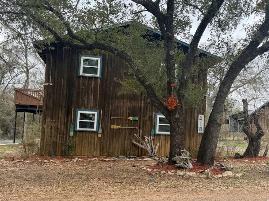 Interior just painted, roof replaced about 8 years ago, new windows, new flooring. Cute 3-bedroom, 2-bathroom, 2 living located in a quiet and peaceful neighborhood located less than 1 mile from Lake Whitney boat ramps (Cleanest Lake in Texas). Large covered outdoor covered area, wrap around balcony, half is covered, BBQ area and outdoor fire pit. Outdoor building can be used as a bar area or storage area. Large 2 car garage with extra storage space. Covered RV storage. Comes with refrigerator, stove, microwave and dishwasher. You will see Wildlife every day. Wonderful area located in the Meridian school district. Also would make a great vacation home!