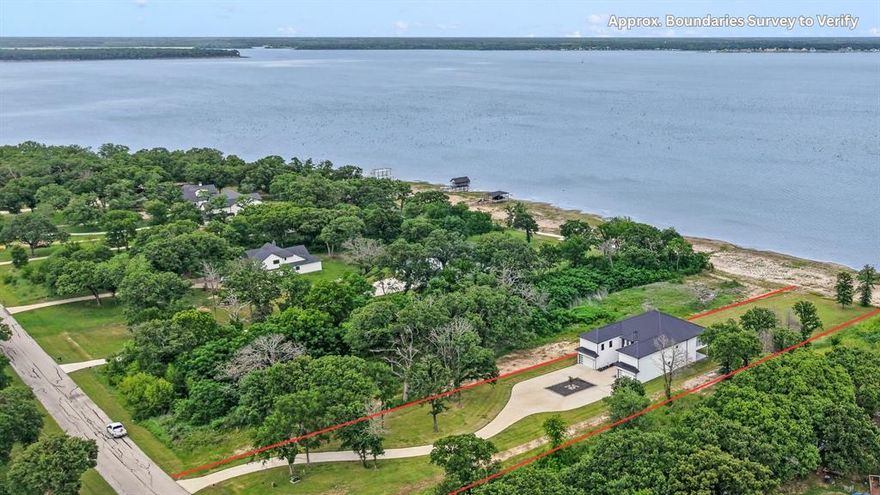 Positioned on 1.5 acres in a gated waterfront community designed for privacy, this 5,000 sq ft modern lake estate offers open water views, beautiful eastern sunrises, and a convenient 55-minute commute to Dallas. A long winding circular drive leads to the home, privately set at the end of a cul-de-sac, featuring contemporary architecture, a dramatic courtyard-style entry, and two separate two-car garages.

Inside, a dramatic two-story wall of glass frames expansive lake views and brings in abundant natural light. The kitchen is thoughtfully designed with a large gathering island, double ovens, a 5-burner gas range, and an oversized walk-in pantry.

On the main level, two waterside ensuite bedrooms feature wood flooring, glass doors opening to private patios, expansive tiled showers, double vanities, and generous walk-in closets—all positioned to capture open water views. An additional full bath with a large walk-in shower and exterior access is ideally suited for guests or convenient use after a day on the water.

Upstairs, two additional private waterside ensuites offer an elevated retreat, each with spacious baths featuring double vanities, soaking tubs, walk-in showers, walk-in closets, private balconies, and sweeping lake views. A loft-style living area overlooking the main level provides flexible space for a second living area or game room, complemented by an additional 430 sq ft media room. An oversized 330 sq ft bonus bedroom with a walk-in closet and adjacent full bath creates an ideal bunk room or additional guest space. A buried propane tank services the kitchen range and two tankless water heaters. The property offers 109 feet of dockable waterfront, with the ability to construct a boathouse subject to approval and permitting through Tarrant Regional Water District.
