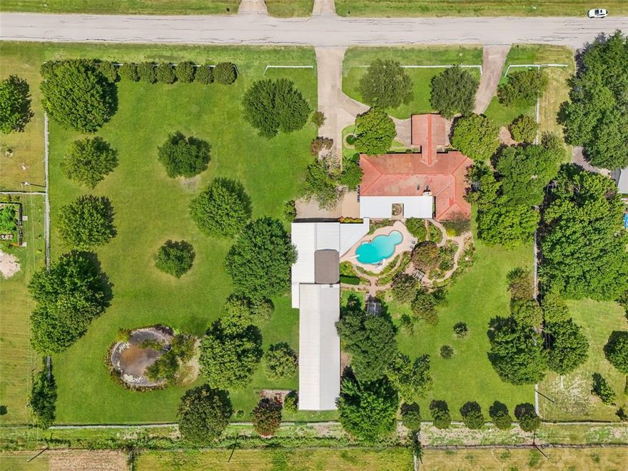 Set on two platted lots totaling about 2.371 acres in Sachse Ranch Estates, this property offers rare land and lifestyle potential. A single story home with guest quarters. The grounds are the showpiece. Elaborate gardens create a Pinterest worthy setting with winding beds, mature trees, a window greenhouse, and two ponds. One is man made and the other is a decorative water feature blended into the gardens. Outdoor living centers around a working clear blue pool and a built in bar that connects to extensive covered patio space for easy entertaining.  Multiple improvements add versatility. A two story guest quarters offers flexible living, office, or studio space. An exterior bathroom serves the pool and garden areas. A large shop of approximately 3200 square feet has electric and water for projects, storage, or small business needs. Additional outbuildings include a detached carport and additional workshop space. The second lot is largely open and fenced, giving options for gardens, play, or possibly another residence.  Buyers and agents should verify horse restrictions, zoning, and any city or private covenant requirements. Information and measurements is provided as a courtesy only and buyers should independently verify all details that matter to them this is an estate property . This is a rare chance to create a custom residence on acreage with established infrastructure in a convenient Sachse location close to major routes, schools, and amenities.