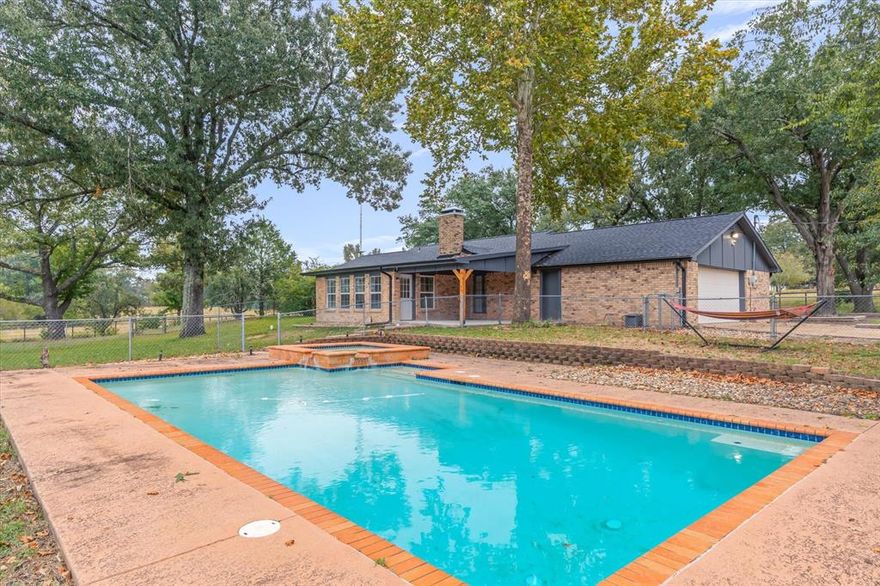 Seller is willing to offer Rate Buy Down!! Welcome to peaceful country living on over 16 beautiful acres! This traditional 3-bedroom, 2.5-bath brick home offers approximately 1,900 sqft of comfortable living space with a versatile bonus room that’s perfect for a home office, workout area, or hobby space.
The kitchen has been refreshed with new granite countertops and freshly painted cabinets, while the primary bath features a soaker tub and updated flooring for a relaxing retreat. The spacious living room centers around a wood-burning fireplace, and large windows provide views of the acreage beyond. Step outside to enjoy the in-ground pool, ideal for relaxing or entertaining. The bonus room leads directly to the covered back patio, creating an easy indoor-outdoor flow. A gated entrance, covered front porch, and extra parking with carport and lean-to pole barn add convenience and plenty of room to cover your farming toys. Bring your horses, cattle, or livestock; this property is already cross-fenced, has pipe fencing along FM 857 frontage, a small pond, and a three-stall horse barn with tack room. The home is on co-op water and septic, with a well for the barn. Enjoy the serenity of country life with easy access to Van, Grand Saline, and Canton; ready for your next chapter in East Texas!
