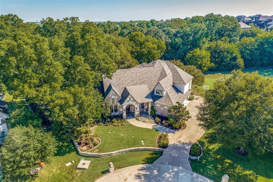 Gorgeous home in the sought after gated community of Stonebridge Estates. This 6 bed, 5 bath home is nestled on a 1.1 acre wooded cul-de-sac lot. Beautiful brick & stone exterior, lush landscaping, 4 car garage, elevator, backyard oasis with huge porch, pool & spa with 7 water features & large grassy areas. Beautiful arched front door welcomes you in. Hand scraped wood floors, tall ceilings, neutral paint & incredible millwork. Large living room with a wall of windows, built ins & fireplace. Kitchen is a chef's dream! Sub Zero built in fridge, Thermador appliances, wine fridge, decorative lighting, fireplace, built ins, coffee station, huge walk in pantry, massive island, open to the kitchen dining area with picturesque views to the backyard. This home is an entertainers dream! Large primary suite & guest room with ensuite down & four huge bedrooms all with ensuites & walk in closets up. Game room, media room & massive walkout attic, his & her offices, mud room & huge laundry room.