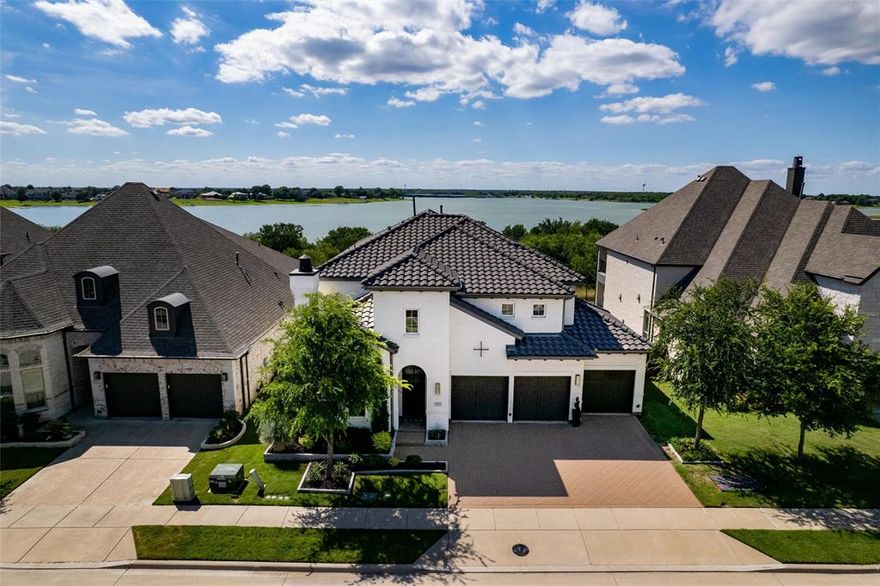 Rare Lakefront Opportunity in Premier Master-Planned Golf Community w Incredible Amenities. Amazing views of Lake especially in Winter & Spring w year around privacy & a gorgeous tree lined lot Welcome to your dream home on one of the most sought-after streets in this prestigious lakeside neighborhood. This custom designed modern masterpiece offers an unmatched blend of luxury, functionality & location, truly the perfect home on the perfect lot. From the moment you arrive, the stunning curb appeal sets the tone for what’s inside. This spacious 4-bedrm, 5-bathrm home features a thoughtfully designed floor plan w no detail overlooked. A dedicated study w built-ins & a stylish formal dining room offer elegant spaces for work & entertaining. At the heart of the home lies a chef-inspired kitchen complete w quartz countertops, upgraded backsplash, top-of-the-line appliances, & abundant storage. The open-concept layout flows seamlessly into the expansive living area w a cozy fireplace, ideal for everyday living & gatherings. The main floor includes both the primary suite & a secondary bedrm w ensuite bath, perfect for guests. Upstairs a custom beverage station, massive second living-flex space, media rm, & two additional bedrms. Designer touches throughout include custom paint, lighting, & curated finishes. Step outside to your private backyard oasis that backs directly to the lake, featuring a covered patio, pergola, & outdoor kitchen w leathered granite countertops. It’s the perfect setting for peaceful mornings or lively evening entertaining. Additional highlights include, Primary Custom closet & Custom Pantry, spacious 3-car garage w built-in storage & access to top-rated schools. Living in the Tribute means more than just owning a home, it’s a lifestyle. Enjoy two golf courses, resort-style pools, an 800-slip marina, on-site dining, lakeside trails, & amenities like dog parks, pickleball courts, a splash pad, kayak-canoe launch & the list goes on for this perfect home