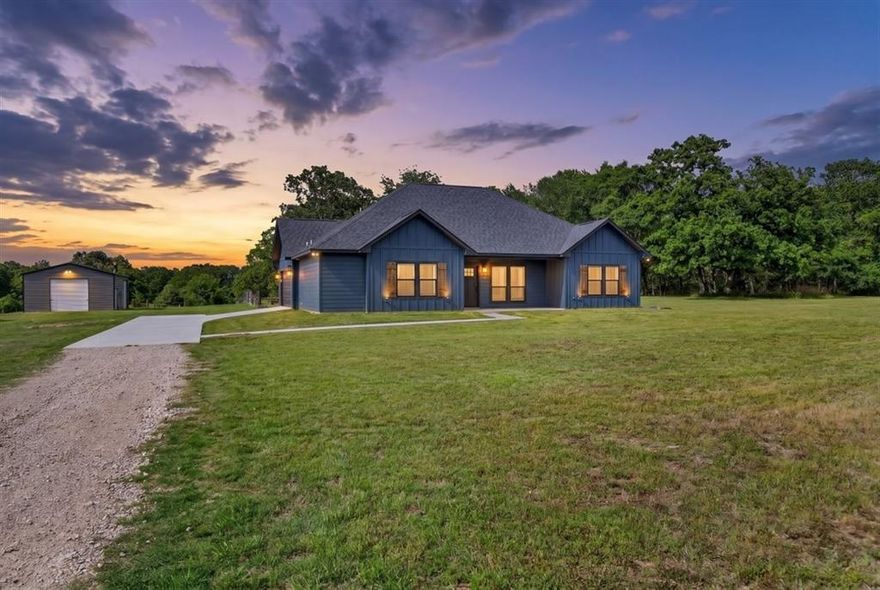 Welcome to a property that effortlessly answers the age-old question: Can I have luxury and elbow room?—with a confident yes.
This 2025 custom-built home sits proudly on 12 acres of Texas beauty, where the long, private driveway ensures two things: 1. you’ll feel like you own your own little kingdom, and 2. unexpected guests will have plenty of time to reconsider. Tucked nearly halfway into the property, the home offers privacy without sacrificing practicality.
Inside, sophistication takes center stage. The countertops are nothing short of showstoppers—equal parts functional workspace and conversation piece—while the richly stained floors bring a level of style that says, “Yes, I have great taste, and yes, I know it.” The layout is designed for both comfort and quiet bragging rights, complemented by a spacious 2-car garage.
Step outside and the land truly shines. Scattered trees are perfectly placed, by God himself, offering shade for cattle and horses who, frankly, will be living a better life than most people. At the same time, there’s plenty of lush pasture for grazing, roaming, or simply pretending you’re going to start a ranch or farm- no judgment here.
And then there’s the 24x30 shop—a space with endless potential. Host gatherings, tackle projects, or finally commit to that hobby you’ve been talking about for years. It’s big enough to make things happen and versatile enough to make excuses disappear.
In short, this property is refined without being fussy, spacious without being overwhelming, and just the right amount of impressive. It’s country living—with a wink and a well-polished finish.