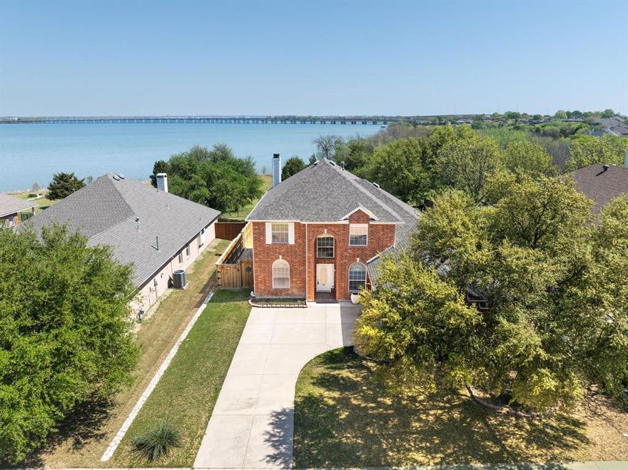 Rare opportunity to own 75 feet of lake frontage inside a gated community with sweeping water views & 
direct access to the city owned shoreline. This lakefront home offers the lifestyle buyers dream about, 
peaceful mornings by the water & unforgettable evenings poolside with family & friends. Inside, 
engineered hardwood floors lead you through an open layout featuring a private study with dramatic 
midnight blue built ins & rolling library ladder, an elegant formal dining room, & a light-filled living area 
framed by a wall of windows overlooking the pool & lake, dressed with electric shades. The beautiful 
kitchen is fully equipped with granite countertops, white cabinetry, travertine backsplash, new 2026 gas 
cooktop, new 2026 wall oven plus convection air fryer microwave combo, Stainless Fridge that remains 
along with walk in pantry. The primary suite captures tranquil lake views & includes a rainfall showerhead, 
separate garden tub, dual sinks, & oversized walk in closet. Upstairs offers a loft, spacious game room 
with lake views, & large secondary bedrooms. The backyard is designed for entertaining with a covered 
patio, play pool with water feature, mature oak tree, grassy yard, wrought iron fencing for unobscured 
views, & private gate access to the lakefront. A true waterfront gem in a convenient location. FULL 
FEATURES LIST AVAILABLE