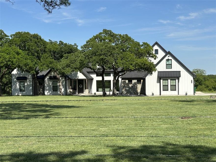 69-acre Equestrian & Cattle property offers a custom-built home with direct access to the LBJ Grasslands, located in Alvord, Texas. The 3,400-square-foot residence features an open-concept design, seamlessly connecting the living room, dining room, and kitchen, creating an ideal space for both family gatherings and entertaining. The living area is highlighted by a dramatic vaulted ceiling and a striking 21-foot stone fireplace, with large windows that allow natural light to flood the interior. A custom designed kitchen with a large granite island that comfortably seats six, a 36-inch six-burner gas cooktop, double ovens with air fry functionality, and a slide-out microwave—all integrated into custom cabinetry. A spacious walk-in pantry also serves as a reinforced concrete safe room. The home offers four generously sized bedrooms, two full bathrooms, and one half-bath on the main level. Upstairs, a versatile bonus room provides the option to serve as a fifth bedroom with an ensuite bathroom and walk-in closet. The first floor features 8-foot doors and 10-foot ceilings throughout, with vaulted ceilings in the living room and two of the bedrooms. For equestrian enthusiasts, the property includes a 36' x 36' horse barn with a 12' x 36' lean-to, featuring three stalls and a tack room. There is also a fenced 100' x 150' arena and a loafing shed. The 30' x 50' insulated workshop offers three roll-up doors, central heat and air, a half bath, a bar, and a 12' x 50' lean-to. The 36' x 60' equipment shed is perfect for storing tractors, trailers, and farm equipment. The property also has pipe working pens for cattle and a 40-foot shipping container for extra storage. Approximately 32 acres of coastal Bermuda grass provide ample grazing land, and the property is cross-fenced to accommodate hay production while pasturing cattle. Water sources include a spring-fed creek that runs through the property and a pond, ensuring sufficient water for livestock.