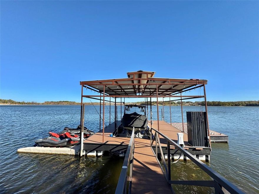 Beautifully Renovated Lake House at Moss Lake!  Discover the charm of lake living in this beautifully renovated Moss Lake retreat—fully furnished and ready to enjoy. The home exudes a quaint, welcoming atmosphere with an open kitchen-and-living concept accented by modern flair and upgraded finishes throughout. Large windows invite in natural light, creating a bright and relaxing gathering space for family and friends.  Step outside to a serene screened-in front porch perfect for morning coffee and quiet evenings. In the back, a spacious tiered deck offers an ideal setting for entertaining, grilling, or simply soaking in the views after a day on the water.  A bonus guest unit adds fantastic flexibility, complete with a double set of bunkbeds—perfect for overflow guests, kids’ sleepovers, or a weekend getaway spot for extended family.  Just a short stroll from the water’s edge, this property includes its own private covered boat dock with a lift, Jet Ski parking, and a generous lounging deck. The dock sits in nice deep water, offering dependable access year-round. Dock slip is leased for just $1,200 per year.