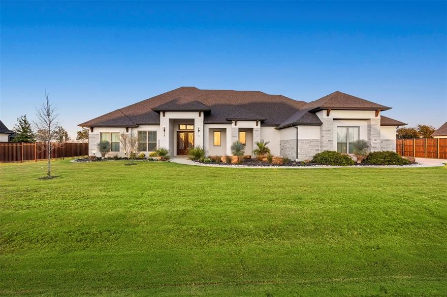 This. Is. It. Welcome to an extraordinary custom retreat nestled on over an acre — a rare opportunity that perfectly blends peaceful country living with everyday convenience. Enjoy the serenity of wide-open space while remaining just minutes from schools, shopping, dining, and easy highway access.

Designed with flexibility in mind, this expansive layout is ideal for growing families, entertaining, or multigenerational living. The formal living room offers warmth and charm with an inviting electric fireplace, while the second living area impresses with soaring vaulted tray ceilings and a wall of windows that flood the space with natural light. Imagine sipping your morning coffee as the sunrise casts golden hues across your private backyard.

The beautifully appointed kitchen is a true showstopper, featuring designer tile backsplash, sophisticated gold accents, gleaming quartz countertops, and a premium Bertazzoni gas range with double ovens — perfect for everyday living or hosting memorable gatherings.

The primary suite serves as a private sanctuary with a spacious walk-in closet and a versatile flex room ideal for an office, fitness space, nursery, or sitting area. The spa-inspired bath includes dual vanities with leather-finished countertops, a freestanding soaking tub, and a custom glass shower. Secondary bedrooms are generously sized and feature walk-in closets.

A fully pre-wired media room offers excellent flexibility and can easily function as a second primary suite if desired. Outdoors, enjoy a covered patio with gas connections for a grill or firepit, upgraded landscaping, full irrigation, and an expansive backyard ideal for relaxation or entertaining.

Additional highlights include an oversized three-car garage with insulated doors, plus a brand-new roof and gutters.