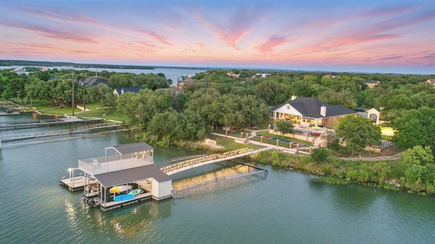 Lakefront luxury meets year-round fun in this fully furnished 3,400 sq. ft. retreat, designed for entertaining and effortless living. This 4-bedroom, 3-bath home features a gourmet kitchen, open-concept living with surround sound, a second living area with beverage stations, and a spa-like master bath with a Mr. Steam shower. Step outside to enjoy a heated Viking volleyball pool, expansive patio with outdoor kitchen, three fire pit areas, a lighted sand volleyball court, and games like ping-pong, axe throwing, and more.

The two-story aluminum dock includes two boat lifts, two jet ski lifts, and full utilities. A 2,300 sq. ft. barn with half bath and an air-conditioned game & weight room offer extra space for hobbies or hosting. Additional perks include a Generac generator, Spider Be Gone system, alarm and lighting, four full RV hookups, and HOA access to The Hideout Golf Club. Just minutes to Brownwood and the airport, this lakefront paradise is ready to enjoy.