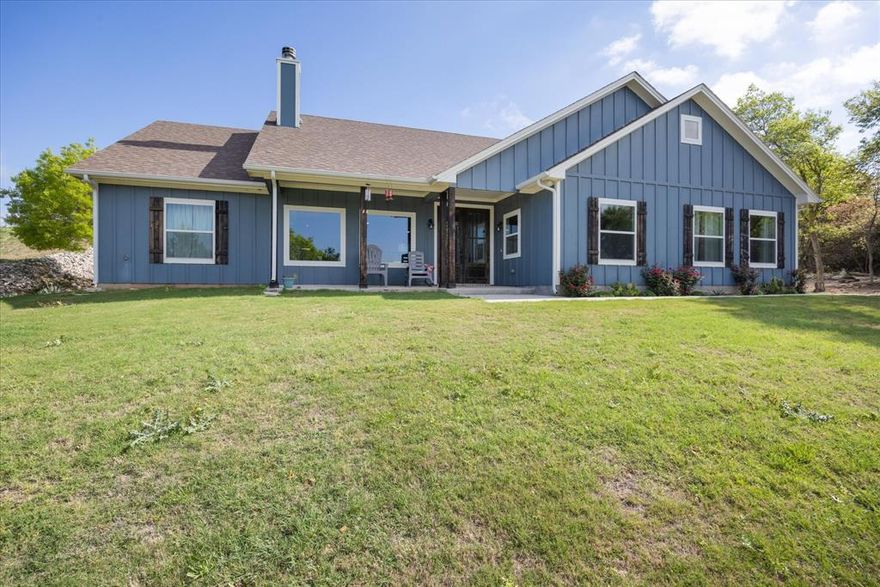 An open, bright and welcoming split-floorplan greets you entering this 2022 built, upscale home, perched on a cleared and landscaped hill in Mountain Lakes Ranch. Expansive regional views from the Living Room, Office, Primary Bedroom and front porch. Abundant cabinetry with a classic farm sink inset in the large island Kitchen with an adjacent walk-in Pantry. A handsome woodburning brick fireplace with hearth and mantle highlights the Living Room. Vaulted and tray ceilings showcase the open feel in the Living Room and Primary Suite. A large 11 x 11 Office is just off the entryway. The oversized laundry room, with sink, has dual access into the main home and into the backside of the Primary walk-in closet. Oversized garage is 27 feet deep. Mountain Lakes is an upscale subdivision with two lakes for fishing and boating. The community has RV parking-storage, private RV camping, a community pool, clubhouse, park and playground. It is located midway between Granbury and Stephenville. Granbury is known for its tourism and boating. Stephenville is home to the exploding Tartleton St. Univ and the Cowboy capitol of Texas. Bluff Dale hosts multiple well known eateries, an historic pub and live music.