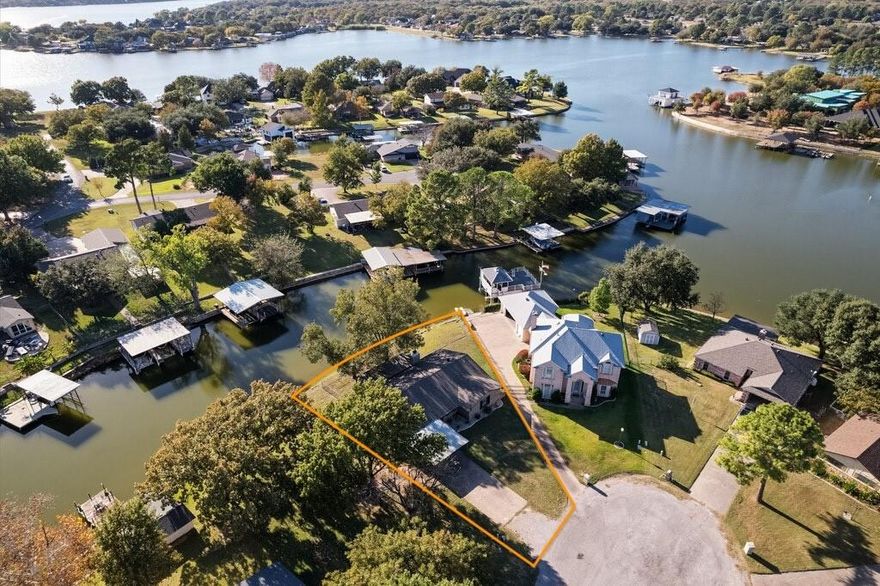 HOME QUALIFIES FOR SPECIAL FINANCING–CALL TO INQUIRE!! LAKEHOUSE-FARMHOUSE!! Discover the perfect blend of farmhouse charm and lakeside living in this beautifully updated lakehouse tucked away on a cul-de-sac with tranquil canal frontage and quick, easy access to the main body of the lake. The towering pecan trees, water views, and inviting outdoor spaces create an ideal setting for relaxation or year-round enjoyment. Enter to an open floorplan designed for both comfort and style. The oversized living area is accented with classic shiplap walls, gray tones, wood-burning fireplace and upgraded lighting enhances the modern farmhouse feel throughout. The fully updated kitchen is a true centerpiece, featuring Hico wood and subway tile walls, high-end KitchenAid stainless steel appliances, including refrigerator, farmhouse sink, quartz counters with generous prep space, and a layout perfect for gathering with family and friends. Expanded pantry added right off kitchen. The bathrooms have also been thoughtfully renovated with stylish finishes, designer tile that continue the home’s cohesive rustic-chic design with antique furniture cabinets. Included washer and dryer make it completely move-in ready. Large windows frame peaceful water views and allow natural light to flow through the open living, dining, and kitchen spaces. Back storm door allows full view an exceptional outdoor living experience. A full covered patio provides the perfect shaded spot for morning coffee or evening conversations, while the adjacent uncovered patio offers additional space for entertaining or soaking up the sun beneath mature pecan trees. Whether you're grilling, lounging, or watching boats glide through the canal, this backyard is made for making memories. Location is just moments from the main lake, this property delivers the ultimate lakehouse lifestyle with a rare combination of charm, comfort, and convenience—your waterfront getaway is ready for YOU.