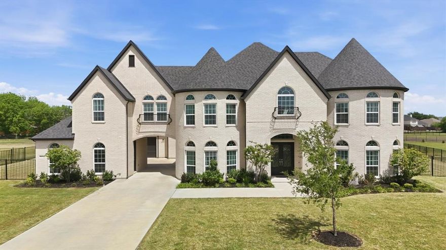 Completed in 2023, this CUSTOM-BUILT 5-bed,5.5-bath porte-cochere home with 4-car garage sits on an open 1.5 acre lot, standing out as a unique residence within the subdivision. Ideal for multigenerational living or elevated guest accommodations, this home offers 2 MASTER SUITES, 2 KITCHENS, and  2 laundry spaces, delivering an UNMATCHED level of rare convenience & luxury. The home's curb appeal is enhanced by its light-colored brick paired aesthetically with a striking, black roof.  Its architectural charm is elevated by 2 stunning turrets, adding a welcoming, timeless character to the exterior. The grand entry further welcomes you through impressive double iron doors into soaring ceilings. Warm, rich wood stairs catch your eye & add sophistication throughout. Inside, a breathtaking family room showcases coffered ceilings & a bold fireplace set against a floor-to-ceiling-tiled accent wall. Elegant double crown molding is found throughout the main areas. Perfect for everyday living or hosting, the home boasts a 2nd kitchen separate with full appliances, complemented by an entertainer's dry bar by the breakfast nook. Both kitchens feature soft-close cabinetry, & soft-closing drawers are found throughout the home, enhancing its designer appeal. All 5 bedrooms are thoughtfully crafted with ceiling fans & integrated lighting. Each offers a private ensuite bathroom with a walk-in shower, ensuring comfort & privacy. One laundry space is discreetly integrated into the upstairs master suite closet for effortless living. Entertainment reaches new heights with a massive media room home theater, pre-wired for a future projector & 7.1 surround sound. Additional highlights include a covered porch with an upper rear balcony & an exquisitely finished iron fence enclosing the backyard for added style whilst spending the evenings outdoors. Offering an unrivaled combination of prestige, flair, & modern living, this extraordinary home is ready for you to make it your own.