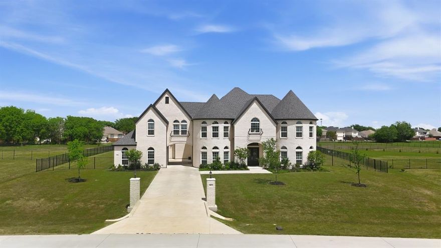 Completed in 2023, this CUSTOM-BUILT 5-bed,5.5-bath porte-cochere home with 4-car garage sits on an open 1.5 acre lot, standing out as a unique residence within the subdivision. Ideal for multigenerational living or elevated guest accommodations, this home offers 2 MASTER SUITES, 2 KITCHENS, and  2 laundry spaces, delivering an UNMATCHED level of rare convenience & luxury. The home's curb appeal is enhanced by its light-colored brick paired aesthetically with a striking, black roof.  Its architectural charm is elevated by 2 stunning turrets, adding a welcoming, timeless character to the exterior. The grand entry further welcomes you through impressive double iron doors into soaring ceilings. Warm, rich wood stairs catch your eye & add sophistication throughout. Inside, a breathtaking family room showcases coffered ceilings & a bold fireplace set against a floor-to-ceiling-tiled accent wall. Elegant double crown molding is found throughout the main areas. Perfect for everyday living or hosting, the home boasts a 2nd kitchen separate with full appliances, complemented by an entertainer's dry bar by the breakfast nook. Both kitchens feature soft-close cabinetry, & soft-closing drawers are found throughout the home, enhancing its designer appeal. All 5 bedrooms are thoughtfully crafted with ceiling fans & integrated lighting. Each offers a private ensuite bathroom with a walk-in shower, ensuring comfort & privacy. One laundry space is discreetly integrated into the upstairs master suite closet for effortless living. Entertainment reaches new heights with a massive media room home theater, pre-wired for a future projector & 7.1 surround sound. Additional highlights include a covered porch with an upper rear balcony & an exquisitely finished iron fence enclosing the backyard for added style whilst spending the evenings outdoors. Offering an unrivaled combination of prestige, flair, & modern living, this extraordinary home is ready for you to make it your own.