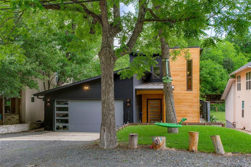 Welcome to 8926 Groveland Drive — a striking contemporary retreat in the heart of Little Forest Hills, just minutes from White Rock Lake. Built in 2020, this thoughtfully designed 4-bedroom home blends modern architecture with warm natural finishes, soaring ceilings, and an open-concept layout ideal for both entertaining and everyday living. The main level features polished concrete floors, expansive windows, and abundant natural light throughout. A chef-inspired kitchen anchors the home with an oversized waterfall island, commercial-grade range, natural wood cabinetry, and seamless flow into the spacious living and dining areas. The downstairs primary suite offers a private escape, while a secondary first-floor bedroom with en-suite bath provides flexibility for guests or multigenerational living. Upstairs, you’ll find two additional bedrooms, each with their own full bath, plus a versatile flex space perfect for a game room, office, gym, or second living area. Designed with functionality in mind, the home also offers generous storage throughout. Step outside to enjoy the beautifully landscaped backyard complete with turf, elevated entertaining deck, mature trees, and peaceful outdoor living spaces that embody the relaxed charm of East Dallas living. Located near local restaurants, coffee shops, and trails, this home offers modern style in one of Dallas’ most beloved neighborhoods.