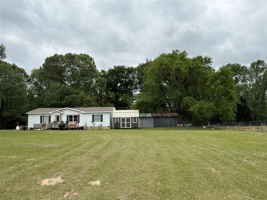 Well-maintained Double wide manufactured home located on 1.4 acres with beautiful mature trees and back seasonal creek. Enjoy your morning coffee on the back patio deck surrounded by trees and listening to the birds. Interior offers open concept with new flooring in living room, kitchen and dining area. Large back patio deck offers privacy, surrounded by trees and overlooking creek. Plenty of space for entertaining family and friends. Property offers 3BR, 2Bath, laundry area located in primary closet area. The cutest shed with electric great for crafts, office, workout room. Large metal workshop approximately 28x35 with electricity, perfect for the handyman. Bring your RV there's electric hookup already on site. When you drive up to property you will be greeted with excellent curb appeal, 2 very tall pine trees are breathtaking. This property has endless possibilities. Backyard has chain link chicken coop and Dog run in place.  Look no further! Schedule your showing today. Manufactured home has previously been moved. All information must be verified.