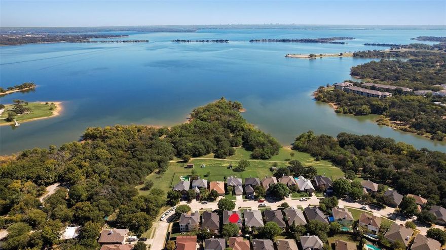 Stunning 4-bedroom, 2.5-bathroom residence in a highly sought-after Lake Dallas neighborhood, just a short walk from Lake Lewisville. With a spacious family and game room, a well-appointed kitchen, and two dining areas, it's perfect for both entertaining and relaxation. The primary suite is conveniently located on the ground floor, featuring a recently updated ensuite bath with modern finishes designed for both comfort and style. A beautifully updated half bath adds an extra touch of sophistication for guests. Unwind in the back yard and patio surrounded by mature trees for shade and privacy, with a professionally installed, well-maintain hot tub, perfect for year-round relaxation. Explore the walking trails. Indulge in exceptional birdwatching, fishing, and boating. The storage shed conveys with the property. This picturesque retreat offers the perfect blend of tranquility and urban accessibility, conveniently located near DFW airport, shopping, and dining. ORIGINAL OWNERS SINCE HOME WAS BUILT.