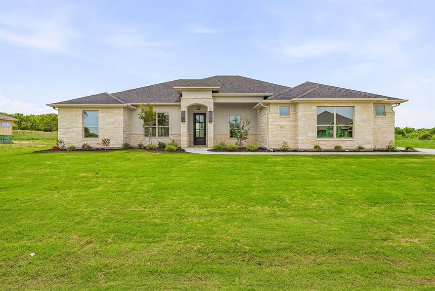 Experience luxury golf course living in this stunning new construction home by BellaVue Homes, perfectly situated on Hole 14 of Squaw Valley Golf Course in highly sought-after Glen Rose, Texas. This beautifully designed 4-bedroom, 3-bath home with an oversized 3-car garage. Step inside to an open-concept floor plan filled with natural light from expansive picture windows, showcasing breathtaking golf course views and a spacious backyard. The living room impresses with soaring 12-foot coffered ceilings and a floor-to-ceiling stone fireplace. The chef’s kitchen is built for both everyday living and entertaining, featuring granite countertops, double ovens, gas range with pot filler, abundant prep space, and a massive walk-in pantry—ideal for those who love to cook and host. Retreat to the luxurious primary suite, complete with a private fireplace and spa-inspired ensuite bath offering dual vanities, a soaking tub, walk-in shower, and a large custom closet with direct access to the utility room for ultimate convenience. A thoughtfully designed split-bedroom layout provides privacy, with a dedicated guest suite and full bath, while two additional bedrooms share a well-appointed bathroom—perfect for family, guests, or a home office setup. Enjoy Texas outdoor living year-round on the expansive covered patio, with ample space to design your dream outdoor kitchen and entertaining area, all overlooking the scenic golf course. Additional premium features include spray foam insulation for energy efficiency, a full sprinkler system, and plenty of room to build a shop or barn—rare flexibility in a golf course community. Located within the top-rated Glen Rose ISD and just minutes from historic downtown Glen Rose, dining, shopping, and outdoor recreation, this home offers the ideal combination of luxury, location, and lifestyle. Don’t miss your opportunity to own a premier golf course home in one of Glen Rose’s most desirable communities.