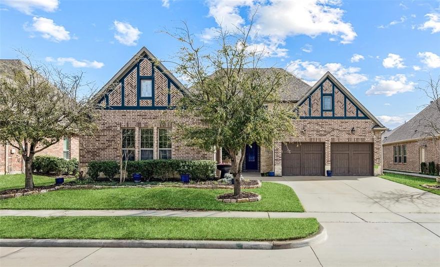 Welcome to this beautifully maintained single-story home in the highly sought-after Waterford Point in The Tribute, where thoughtful design, modern upgrades, & exceptional community amenities come together. A stunning custom front door welcomes you into a bright open-concept layout designed for comfortable living & entertaining. The spacious living room features exposed wood beams, cozy fireplace, & engineered wood flooring throughout, creating a warm yet elegant gathering space. A sliding glass door opens to the backyard, connecting indoor & outdoor living. The home includes surround sound, motion sensors, & security cameras installed by Home Pro. The living area flows into the kitchen featuring a large island, granite counters, gas cooktop, & ample cabinetry. The fridge stays with the home, adding convenience for the next owner. Just off the living room, you’ll also find a bar area with its own fridge that conveys, making it easy to entertain. An office with custom built-in shelving offers a beautiful & functional work space & could easily be converted into a 4th bedroom. The primary is generously sized, highlighted decorative accent wall that adds character & charm. The ensuite bath offers a large double vanity with a seated prep area, spacious shower with dual shower heads, & linen closet, creating a relaxing retreat. 2 additional bedrooms provide flexibility, with one featuring a Murphy bed that will remain with the home. Additional highlights include a large laundry room with space for a freezer & 2 garages with epoxy floors & overhead storage plus floored attic for even more storage options. Living in The Tribute means enjoying resort-style amenities including 2 community pools, splash park, miles of scenic walking & biking trails, fitness center, & clubhouse. A vibrant new marina & lakeside park—coming soon will further enhance the community’s lakeside lifestyle on Lake Lewisville. Located with easy access to FM 423, TX-121, & the Dallas North Tollway.