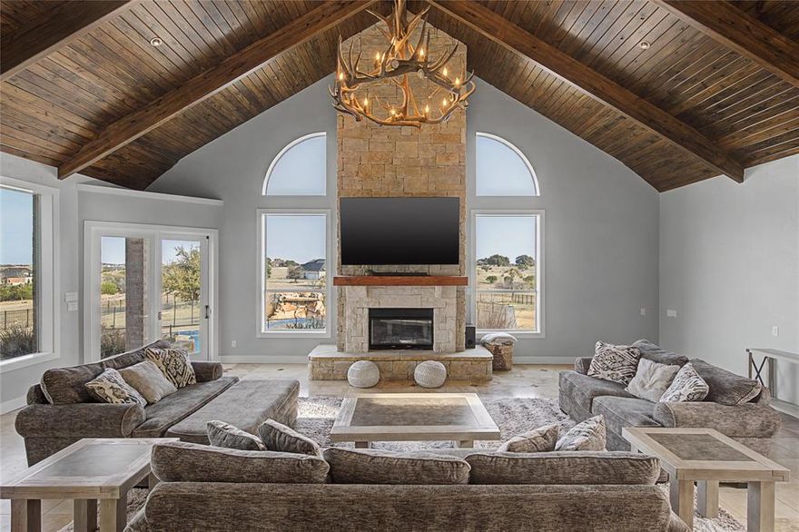 Situated on 2.13 acres inside the gated community of Canyon West Golf Club, this extraordinary estate blends refined luxury with sweeping Texas views. Designed for both grand-scale entertaining and everyday comfort, the home offers an impressive layout with expansive living spaces filled with natural light framed by vaulted wood-beamed ceilings, dramatic windows and a stunning floor-to-ceiling stone fireplace. The chef’s kitchen is a true showpiece, featuring Viking appliances, a twin Sub-Zero refrigerator and freezer, oversized island with prep sink, and rich stone finishes. The open design flows seamlessly into the main living areas, making it ideal for gatherings. The private primary retreat is a sanctuary of its own, complete with a fireplace, spa-inspired bath with dual vanities, freestanding soaking tub, dual-head walk-through shower, and an architectural stone feature wall that makes a bold statement. Specialty spaces elevate this home to the next level, including an expansive game room with wet bar, exercise room with mirrored walls and rubber flooring, safe storage room, and both upstairs and downstairs laundry rooms for ultimate convenience. A separate mother-in-law suite provides flexibility for guests or multi-generational living. Step outside to a resort-style backyard designed for unforgettable entertaining. The diving pool and spa feature a cascading waterfall, expansive decking, and multiple lounging areas — all positioned to capture the elevated views. An outdoor kitchen, pergola-covered patio, fire pit, and beautifully landscaped grounds complete the experience. The gated drive and detached 4 car garage add both function and presence to this estate-sized property. Located within Canyon West, residents enjoy a golf course setting while remaining just minutes from Weatherford with convenient access to Fort Worth. This is more than a home, offering space, sophistication, and lifestyle in one of Parker County’s most desirable gated communities.