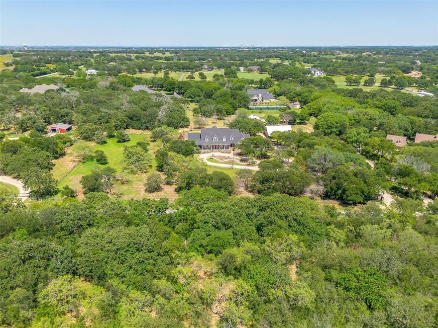 This stunning 5±AC equestrian estate in Argyle ISD is a horse enthusiast's dream. Residing 30min from DFW airport & 10min from the heart of Argyle, the stunning estate boasts mature trees, creating a serene & private setting. The residence offers inviting living spaces, complete w 5 bedrooms (one could be office), incredible wide plank pine hardwood floors & a gorgeous stone fireplace. A gourmet chef's kitchen offers ample storage, a large gas cooktop, butcher block island, & dual sinks. Enjoy entertaining in the large, warm living spaces including a screened patio, game room & pool. Beyond the residence, is two insulated Morton barns. The main barn offers 4 stalls w runs, cross ties & wash rack. The second is an insulated workshop that could be converted into additional stalls. Situated on a quiet cul-de-sac, the gated property offers two circular drives designed to accommodate horse trailers. Pastures are cross fenced & irrigated w deep water well. Ag exempt, no HOA.