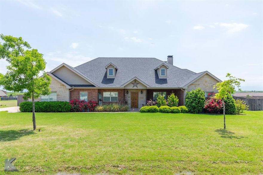 Stunning home with all the bells and whistles in Wylie West! Sitting on 1.649 acres with beautiful hill side views, this home features a chef's kitchen perfect for any holiday or family gathering with an open living area to make entertaining a breeze. This breathtaking 4-bedroom home offers a gourmet kitchen, split bedroom floor plan and a spacious additional room which could be an office, home school area, craft room, media room, gym  or 2nd primary with a bath just across the hall. The soaring vaulted ceilings and rock fireplace create a warm, inviting living space. Enjoy the backyard with a wood burning fireplace on the back patio and a gorgeous, heated in-ground pool with pergola just perfect for entertaining and Summer fun! The luxurious sequestered primary suite boasts a spa-like bath and dream closet. This home sits just outside the city limits of Abilene. Some upgrades include fresh paint 2022, pool pump and filter replaced in 2022, roof replaced in 2024 and aerobic septic system pump replaced in 2025.  This home has been immaculately kept! Don't miss out, schedule your private showing today!