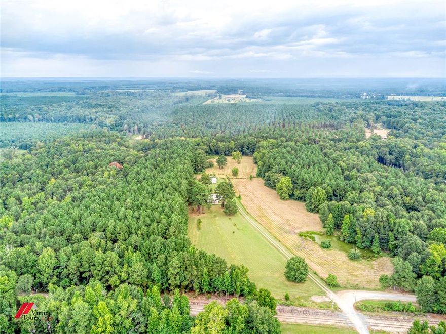Beautiful acreage with lots of trees and small creek. Part of the acreage may be low in spots, but all of the property is in Zone X.    The back section of the  acreage has a cleared area.  (SEE AERIAL PHOTO ). The 10.85 acres is to the left of the 10 acres with house. The front of the property faces the rail road track easement.  The 10.85 mostly wooded acres is close to the boundary line along the 10 cleared acres and goes to the back where the cleared acreage ends.  Survey and tax assessor aerial view with the marked boundary lines is available.  Seller reserves mineral rights.   Servitude of Passages are currently being updated and to be recorded at Courthouse.